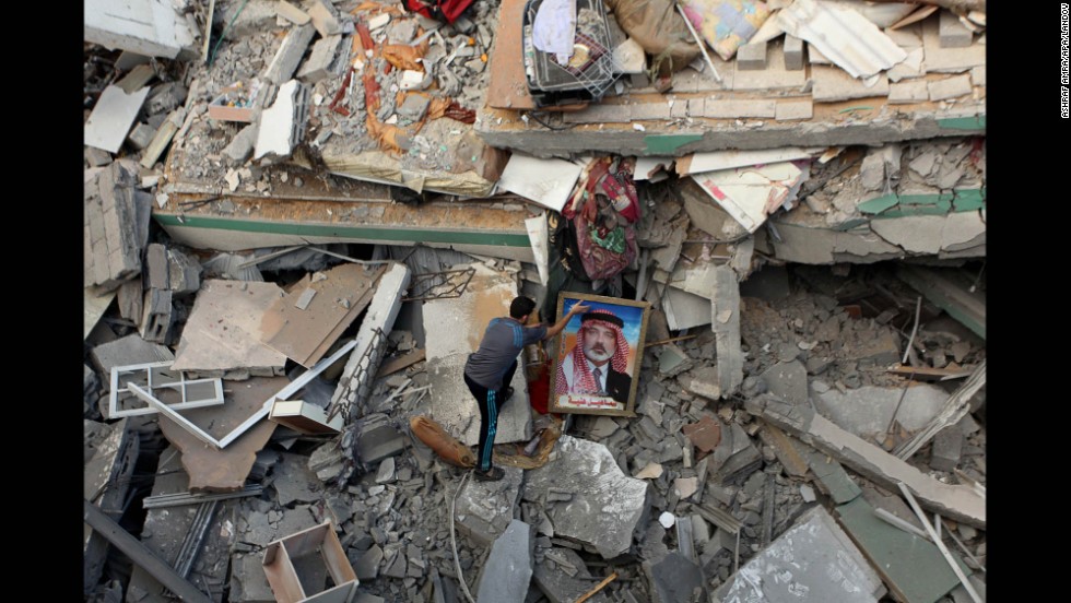 A Palestinian man places a portrait of Hamas leader Ismail Haniya on the rubble of Haniya&#39;s Gaza City home July 29 after it was hit by an overnight airstrike.
