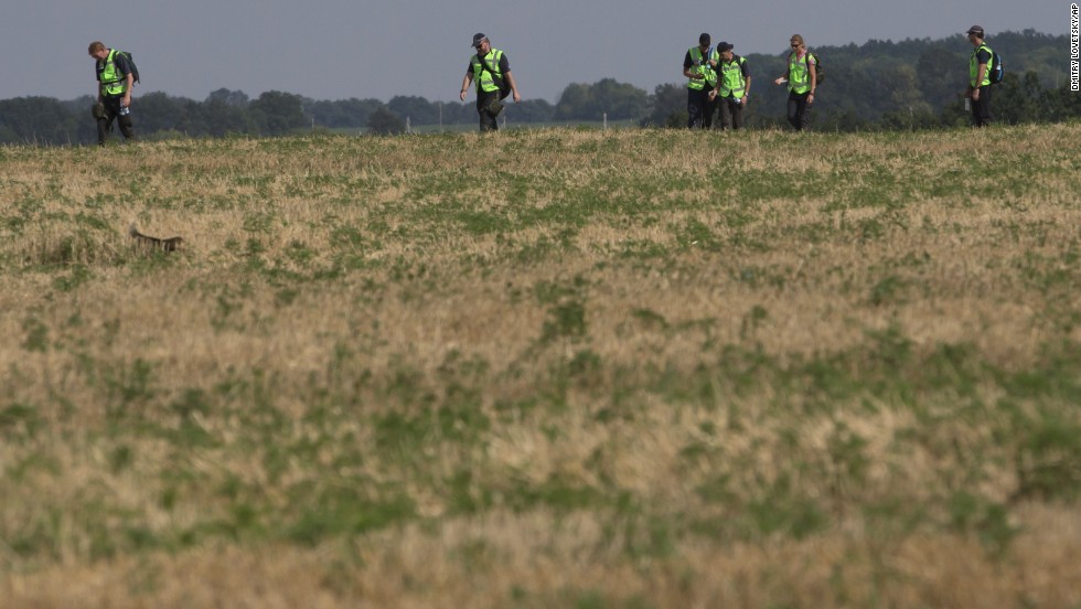 Australian and Dutch experts examine the area of the crash on August 3, 2014.