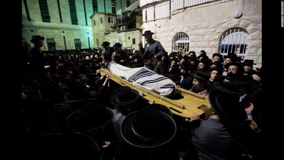The body of Avrohom Wallis is carried during his funeral in Jerusalem on Monday, August 4. Wallis was killed in what Israeli police spokesman Micky Rosenfeld called a &quot;terror attack,&quot; when a man drove an earthmover into a bus in Jerusalem.