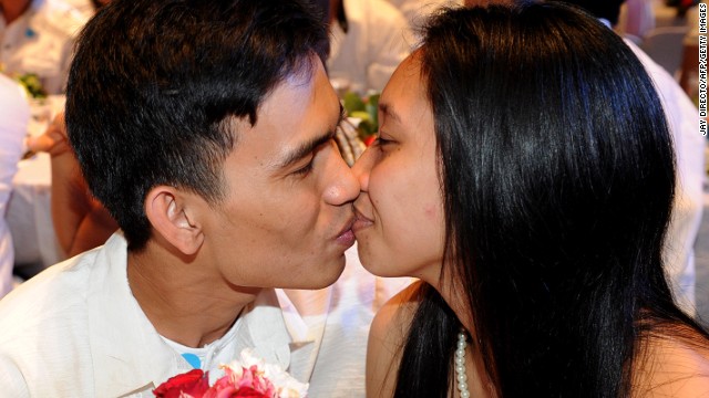 A newlywed couple kiss at a wedding ceremony in Manila on Valentine&#39;s Day last year.