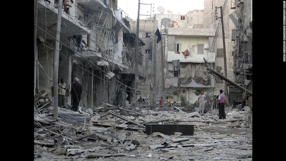 Residents inspect the rubble of destroyed buildings in Aleppo after Syrian regime helicopters allegedly dropped barrel bombs there on Wednesday, August 13.