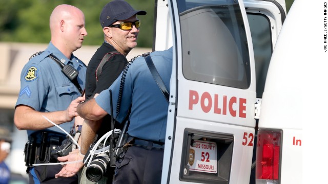 Getty Images staff photographer Scott Olson is placed into a paddy wagon after being arrested.