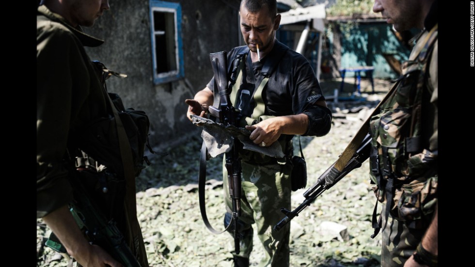 A pro-Russian rebel holds shrapnel from a rocket after shelling in Donetsk on August 22.