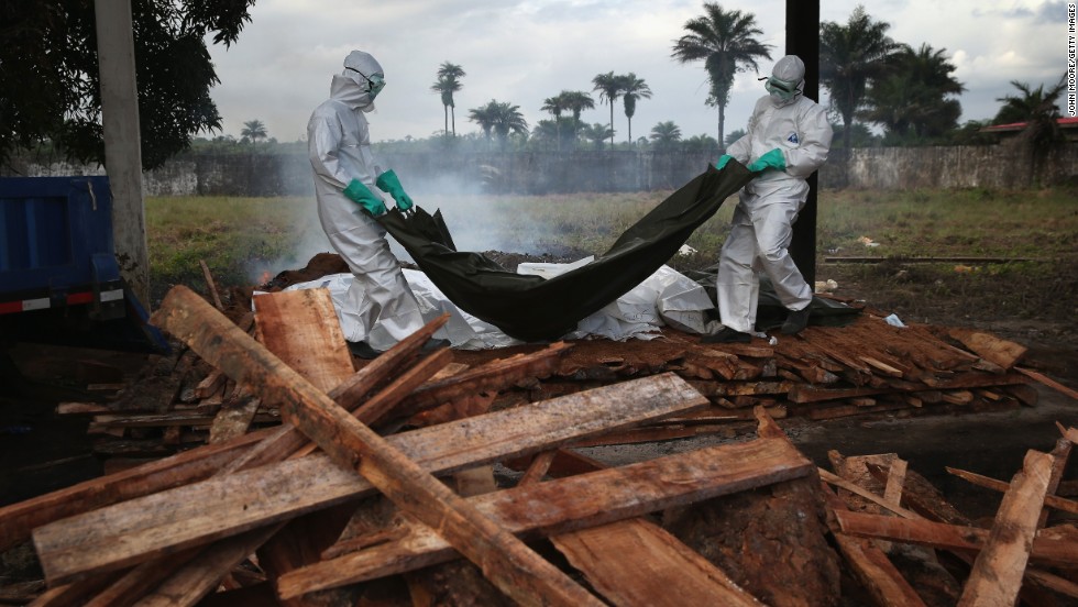 A burial team from the Liberian Ministry of Health unloads bodies of Ebola victims onto a funeral pyre at a crematorium in Marshall, Liberia, on August 22, 2014.