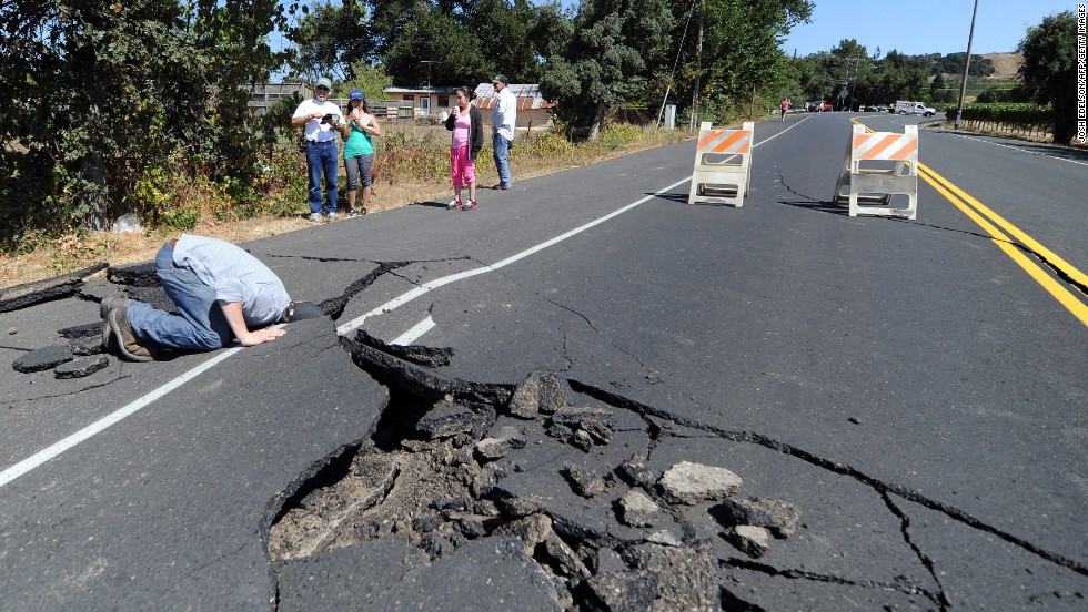 Nicholas George looks under a buckled highway just outside of Napa on August 24. 