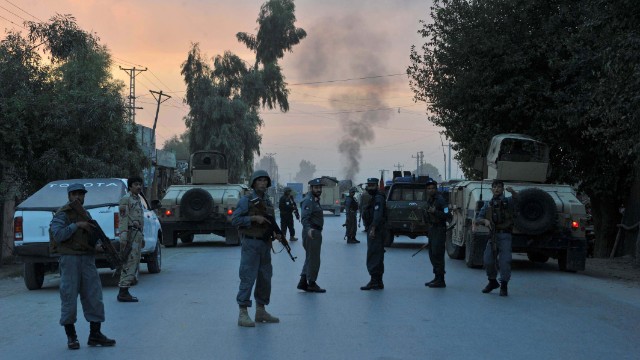 Afghan policemen keep watch after the attack by Taliban militants on the Afghan intelligence service office in Jalalabad.
