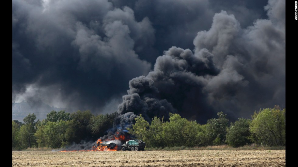 Unmarked military vehicles burn on a country road in Berezove, Ukraine, on September 4 after a clash between Ukrainian troops and pro-Russian rebels. For months, Ukrainian government forces have been fighting the rebels near Ukraine&#39;s eastern border with Russia. 