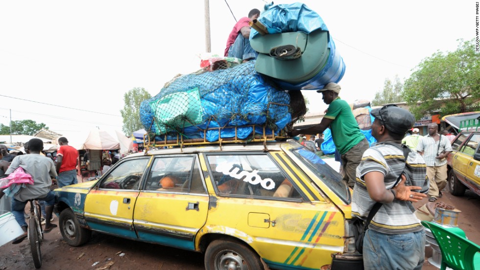 After an Ebola case was confirmed in Senegal, people load cars with household items as they prepare to cross into Guinea from the border town of Diaobe, Senegal, on September 3, 2014.