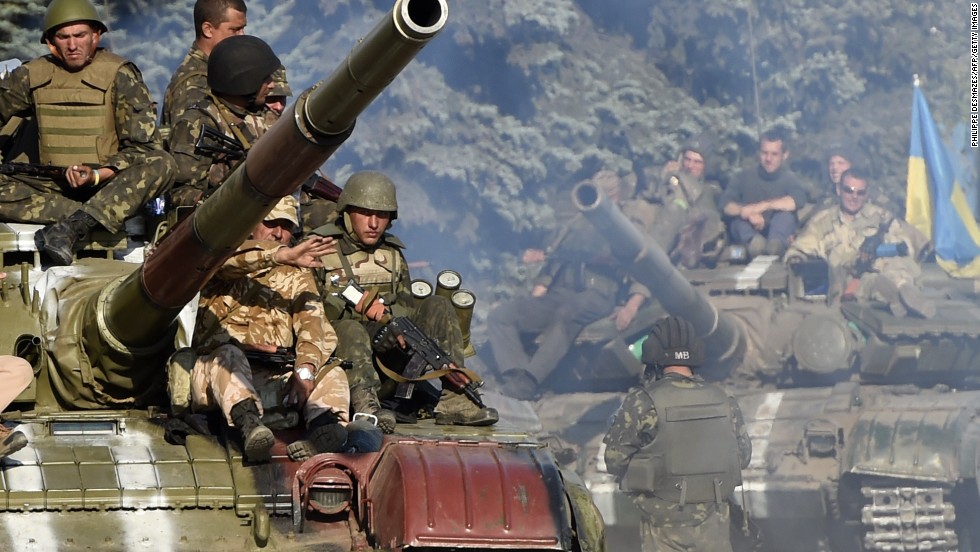 Ukrainian soldiers ride a tank on a road close to where pro-Russian rebels fired heavy artillery outside Mariupol on September 5.