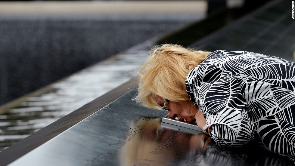 Paola Braut, of Belgium, kisses a photograph of her son Patrice along the edge of the North Pool of the World Trade Center site.