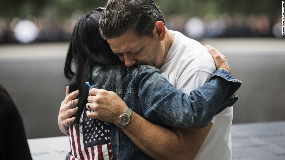 Eileen Esquilin hugs her husband, Joe Irizarry, while mourning the loss of her brother, Ruben Esquilin Jr., during memorial observances in New York.