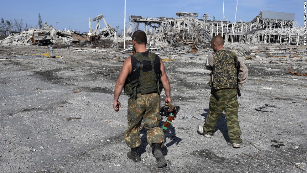 Armed pro-Russian rebels walk September 11 in front of the destroyed Luhansk International Airport. The rebels took control of the airport on September 1 after heavy fighting with the Ukrainian army. 