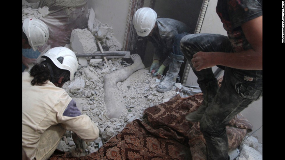 Residents of Aleppo remove a body from debris on Friday, August 29, after what activists claim was shelling by forces loyal to al-Assad.