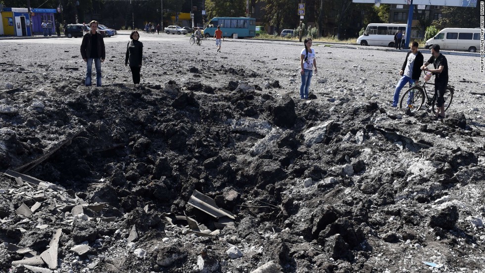 People look at a large crater from a reported missile strike that hit a bus station Friday, September 12, in Makiivka, Ukraine.