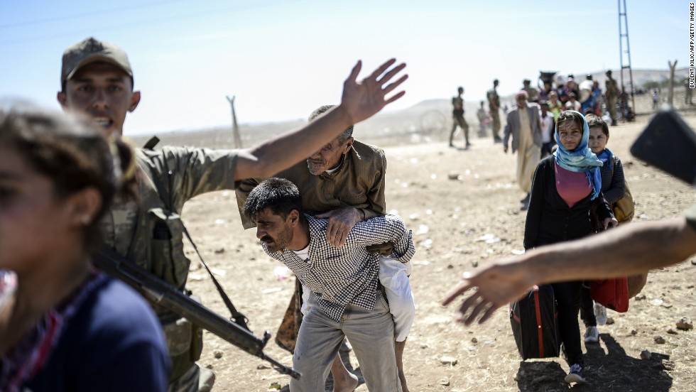 A elderly man is carried after crossing the Syria-Turkey border near Suruc on Saturday, September 20.