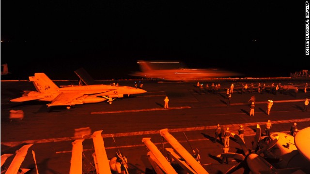 In this photo released by the U.S. Navy, A-18E Super Hornet, attached to Strike Fighter Squadron (VFA) 31, and an F/A-18F Super Hornet, attached to Strike Fighter Squadron (VFA) 213, prepare to launch from the flight deck of the aircraft carrier USS George H.W. Bush (CVN 77) to conduct strike missions against Islamic State group targets, in the Arabian Gulf, Tuesday, Sept. 23, 2014. 