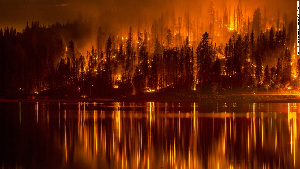 There&#39;s not a direct link between climate change and wildfires, exactly. But many scientists believe the increase in wildfires in the Western United States is partly the result of tinder-dry forests parched by warming temperatures. This photo shows a wildfire as it approaches the shore of Bass Lake, California, in mid-September. 