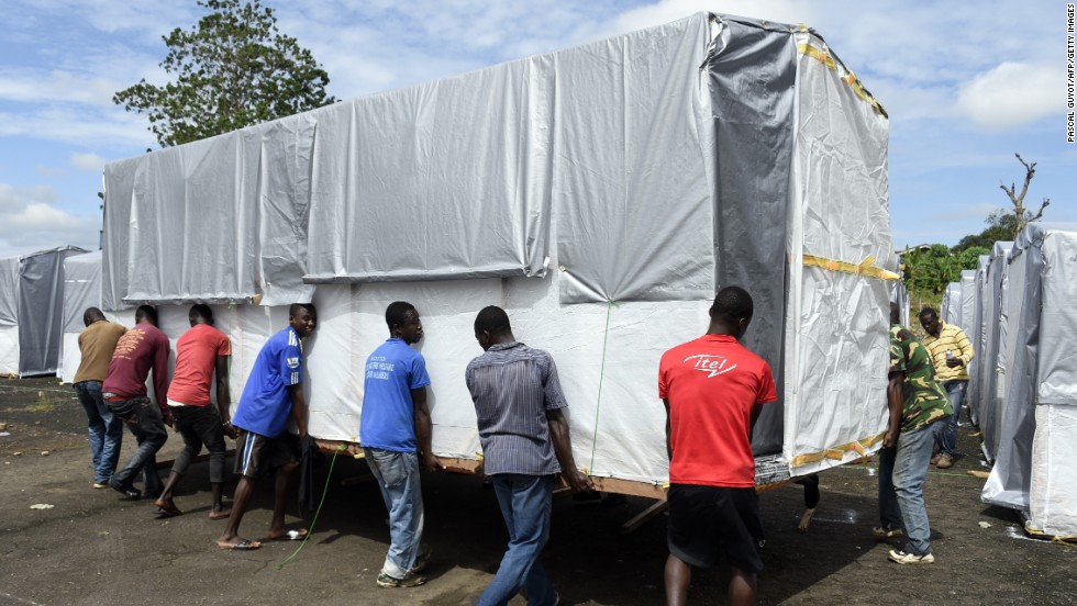 Workers move a building into place as part of a new Ebola treatment center in Monrovia on September 28, 2014.