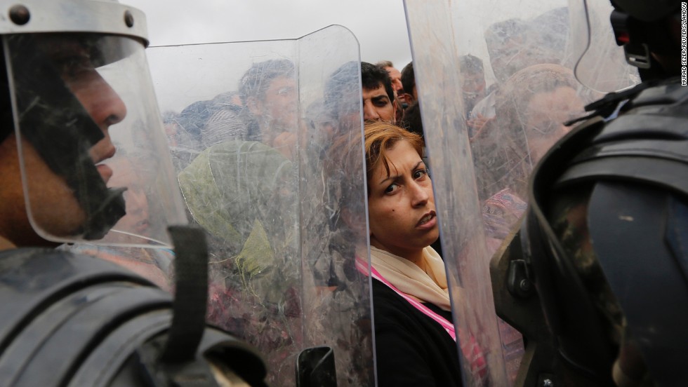 Syrian Kurds wait near a border crossing in Suruc as they wait to return to their homes in Kobani on Sunday, September 28.