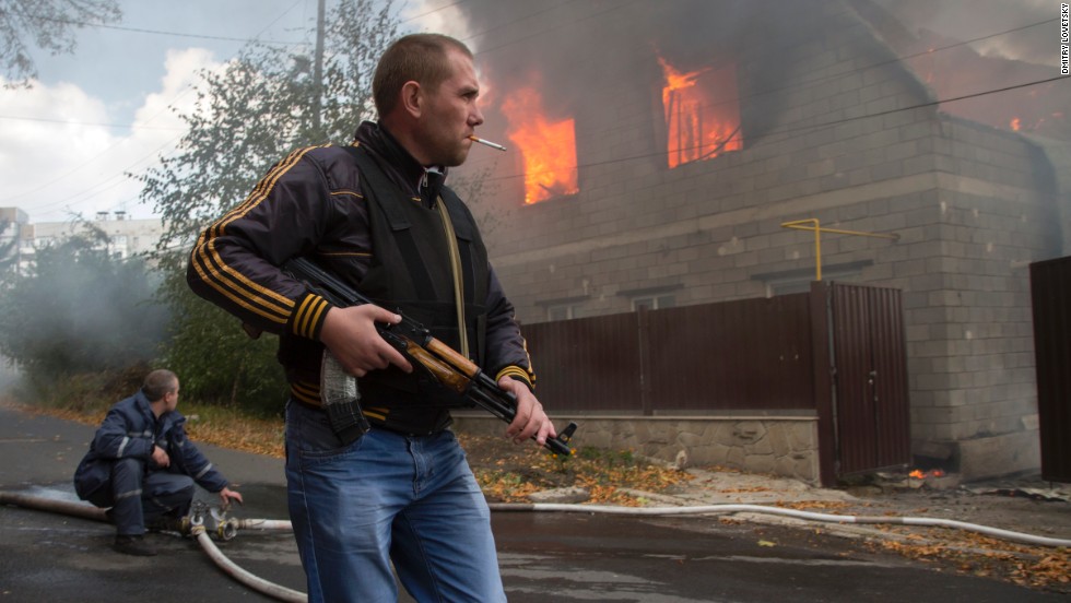 A pro-Russian rebel walks past a burning house after shelling in the town of Donetsk, Ukraine, on Sunday, October 5.