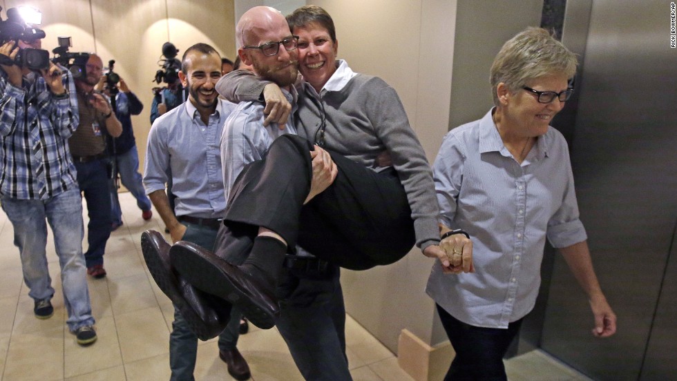 From left, plaintiffs Moudi Sbeity; his partner, Derek Kitchen; Kody Partridge; and Partridge&#39;s wife, Laurie Wood, celebrate after a news conference in Salt Lake City on October 6, 2014. The U.S. Supreme Court cleared the way for same-sex marriage in Utah when it declined to hear the state&#39;s appeal of a lower court ruling. 