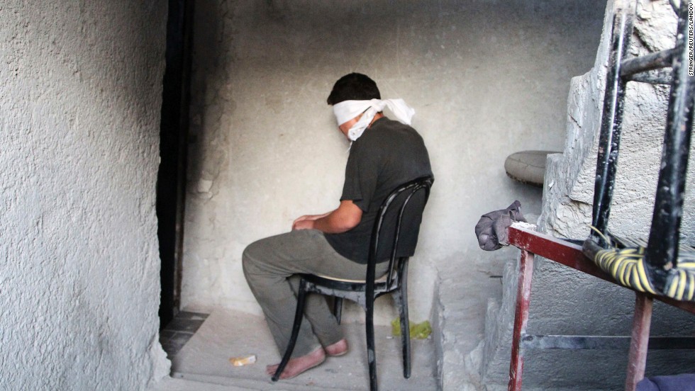 A blindfolded man suspected of passing military information to the Syrian government waits to be interrogated by Free Syrian Army fighters Monday, October 6, in Aleppo.