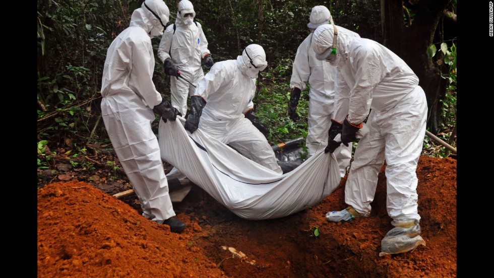 Health workers bury a body on the outskirts of Monrovia on October 20, 2014.