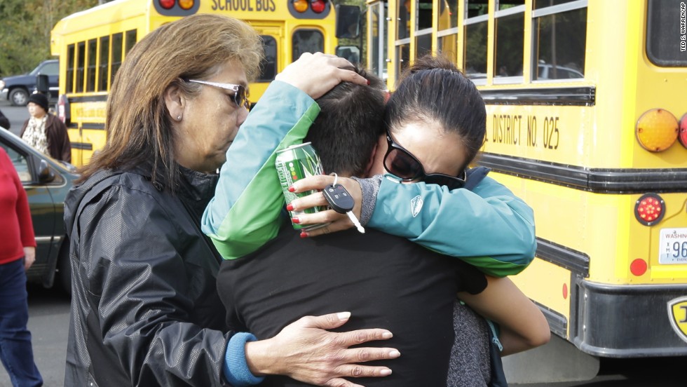People embrace at the church where students were taken to be reunited with parents.