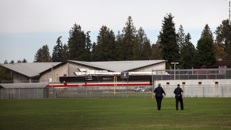 Police monitor the school&#39;s athletic fields after the shooting. 