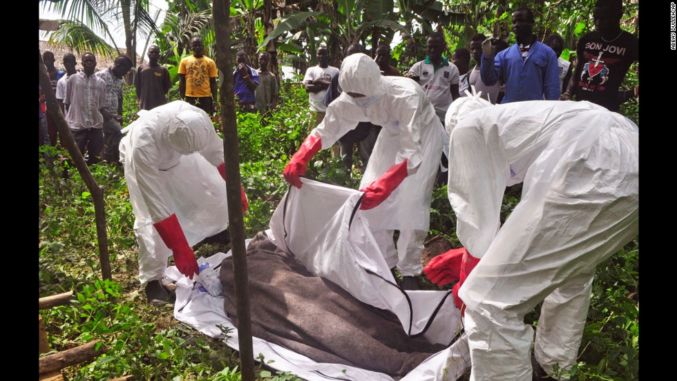 Health workers in Monrovia cover the body of a man suspected of dying from the Ebola virus on October 31, 2014.