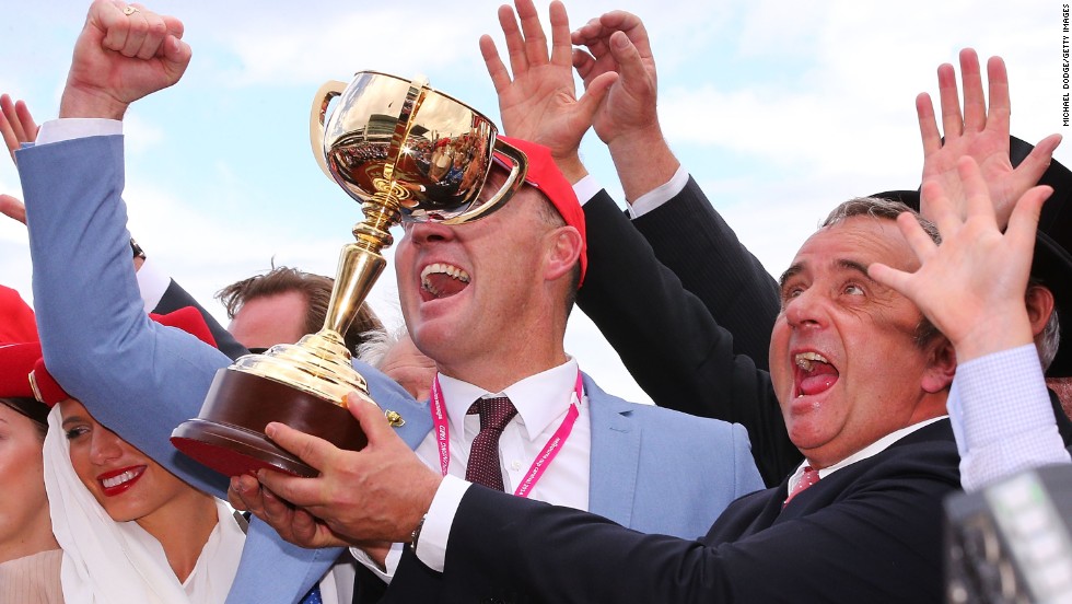 Euphoric Protectionist trainer Andreas Wohler celebrates with the trophy after winning race 7 of the prestigious Melbourne Cup.