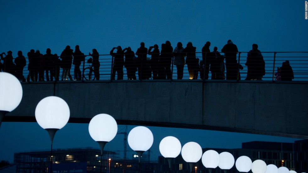 People look at balloons of the art project Lichtgrenze (Border of Light) in Berlin. 