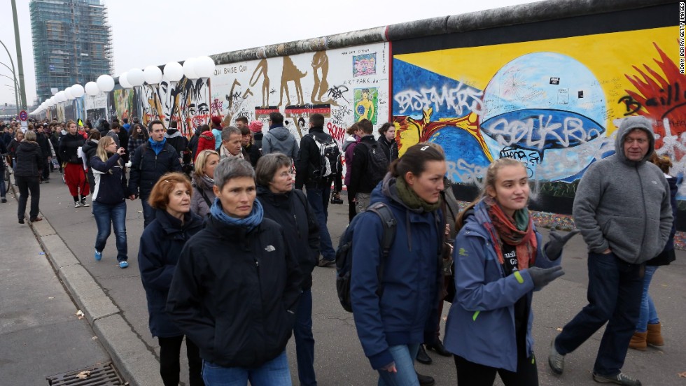 Visitors walk by East Side Gallery, a section of the former Berlin Wall, during the anniversary celebrations.