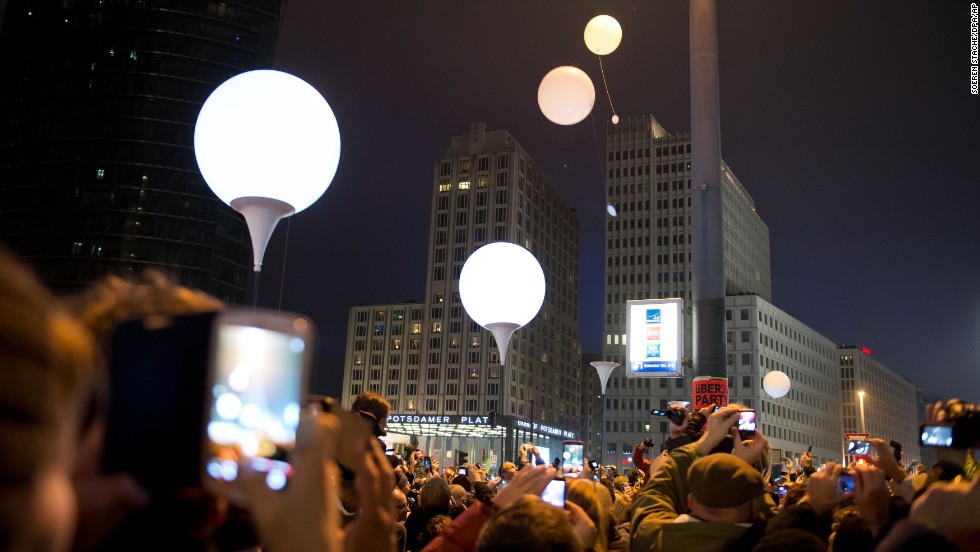 Balloons from the art installation Lichtgrenze 2014 fly away at Potsdamer Platz to commemorate the fall of the wall in Berlin, Germany, on Sunday, November 9. The art installation featuring 8,000 luminous white balloons commemorates the division of Berlin by marking the path the wall once followed. 