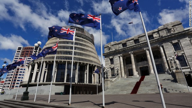 New Zealand flags fly in front of The Beehive and Parliament House in Wellington, New Zealand.