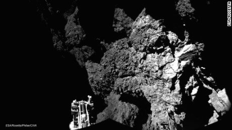 Il lander Philae della sonda Rosetta è mostrato seduto sulla cometa 67P/Churyumov-Gerasimenko dopo essere diventato la prima sonda spaziale ad atterrare su una cometa il 12 novembre 2014. Gli arpioni della sonda non sono riusciti a sparare, e Philae ha rimbalzato alcune volte. Il lander è stato in grado di inviare immagini e dati per 57 ore prima di perdere potenza.