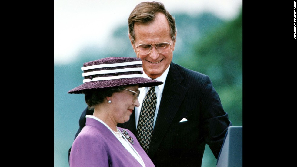 President George Bush steps aside for Queen Elizabeth II to address the crowd attending a welcoming ceremony at the White House in Washington, DC, on May 14, 1991.