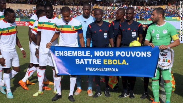 Mali&#39;s team captain Seydou Keita (C) and Algeria&#39;s captain Medhi Lacen hold a banner reading &#39;&#39;Together we can fight Ebola&#39;&#39; during Africa Cup of Nations qualifying.