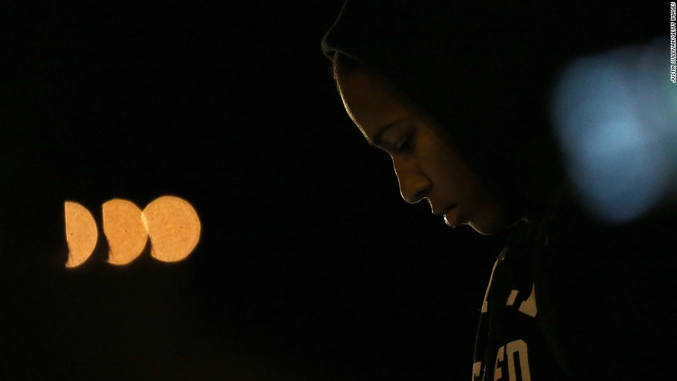 A demonstrator listens to a car radio as the grand jury&#39;s decision is delivered in front of the Ferguson Police Department.