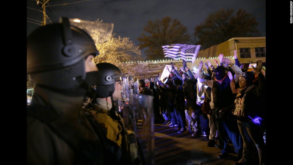 Police officers stand guard as protesters confront them on November 24.