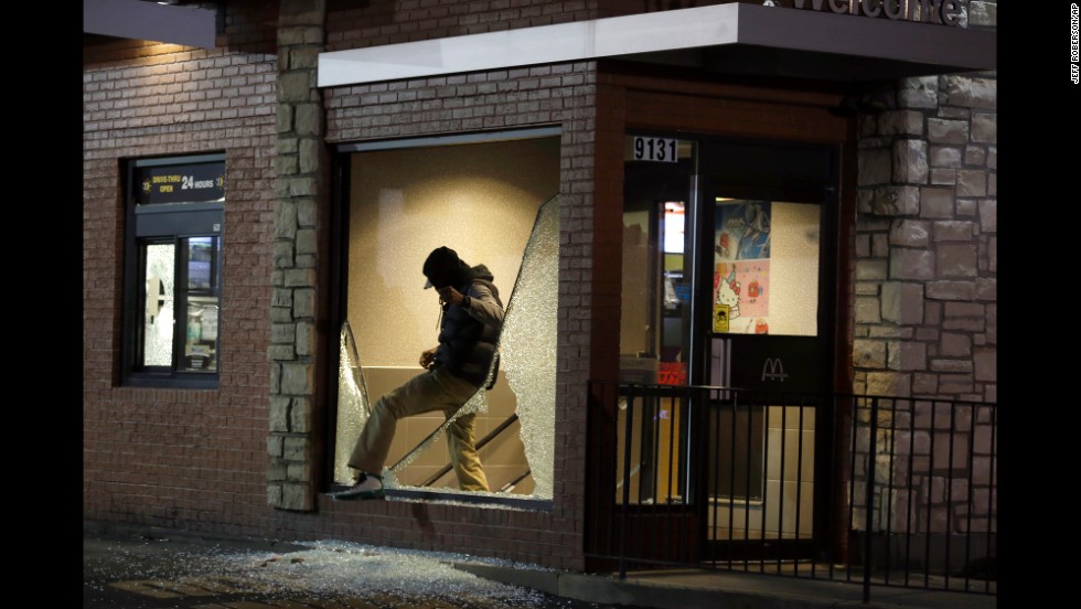 A man steps out of a vandalized store on November 24.