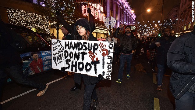 Demonstrators hold up placards and march down Oxford Street in central London on November 26, 2014 during a protest over the US court decision not to charge the policeman who killed unarmed black teenager Michael Brown in the town of Ferguson. The policeman whose killing of unarmed black teenager Michael Brown sparked weeks of riots in the US town of Ferguson will not face charges, the county prosecutor said on November 25, amid mounting anger in the streets. Over a thousand people demonstrated outside the US embassy in London, holding up their hands and waving placards. The demonstration then turned into a march along Oxford Street, one of central London&#39;s main retail and shopping streets. AFP PHOTO / LEON NEALLEON NEAL/AFP/Getty Images