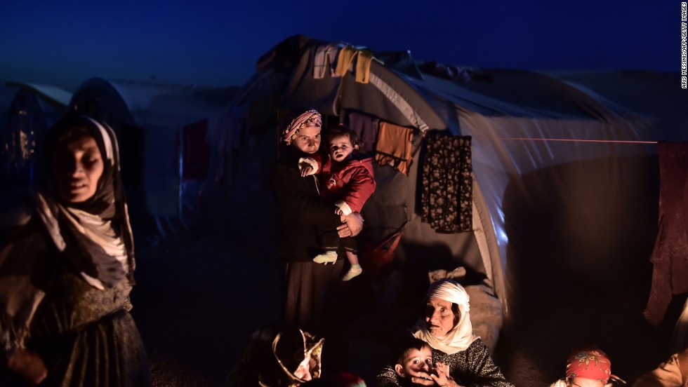 Syrian Kurdish refugees sit outside tents at a camp in Suruc on November 11.