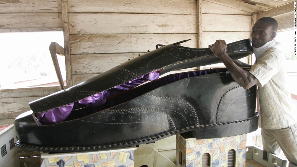 A Ghanaian undertaker opens a coffin, shaped like a shoe, in his showroom in Accra in 2008. 