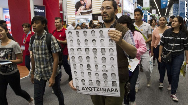 People take part in a protest for the 43 missing students at the International Book Fair in Guadalajara, Mexico, on December 3, 2014. AFP PHOTO/Hector GuerreroHECTOR GUERRERO/AFP/Getty Images