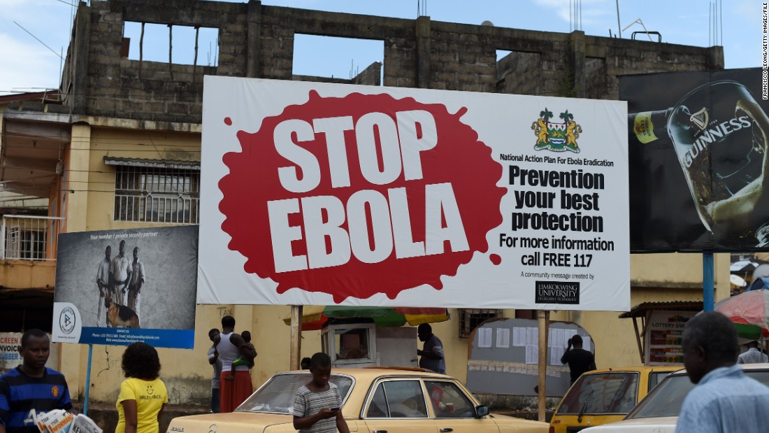 Community awareness was also a priority during the 2014 Ebola outbreak. Pictured, people walk past a billboard with a message about Ebola in Freetown, Sierra Leone.