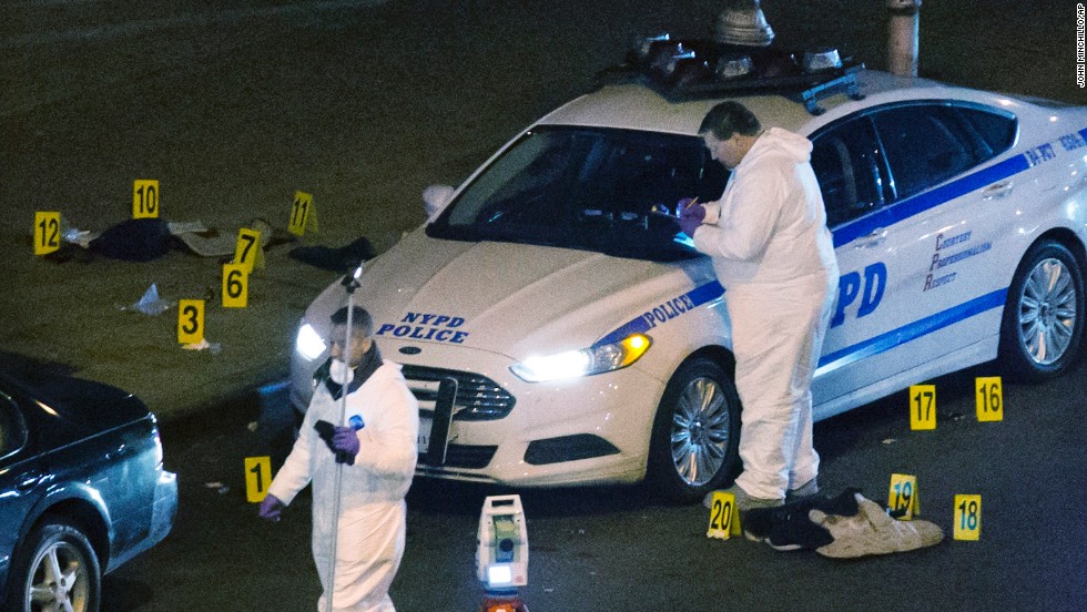 Investigators work the scene where two NYPD officers were shot December 20, in the Bedford-Stuyvesant neighborhood of Brooklyn, New York. 