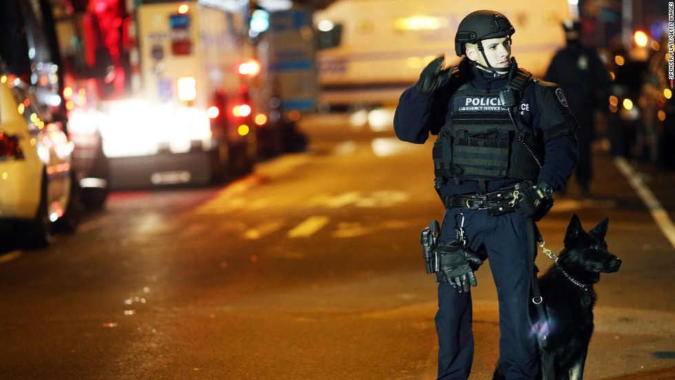 An officer with a police dog monitors the scene on the evening of December 20. 