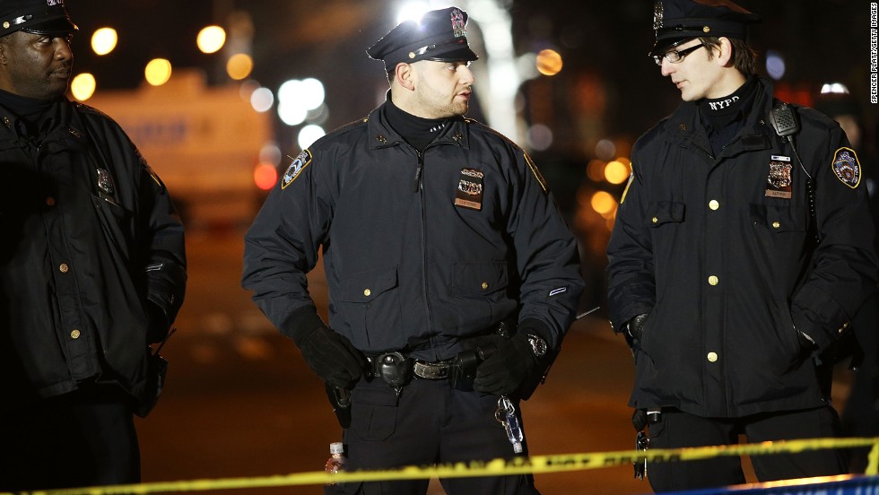 Police officers gather near the scene of the shooting. U.S. Attorney General Eric Holder called the attack &quot;an unspeakable act of barbarism.&quot;          