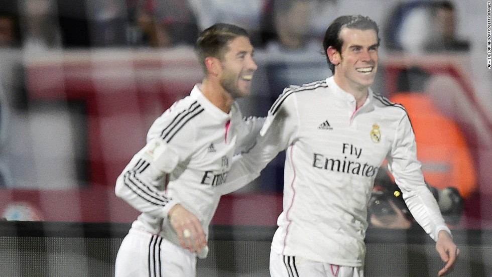 But the smiles are soon back for Real Madrid when Gareth Bale (right) scores a second goal against San Lorenzo.